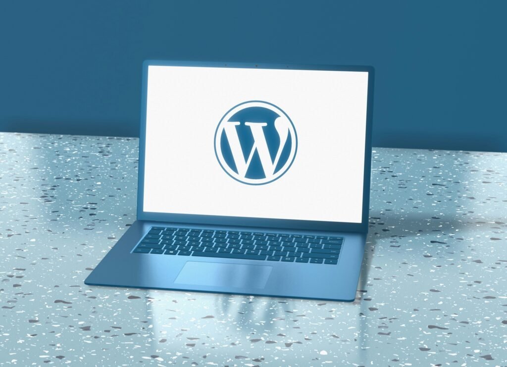 A blue laptop displays the WordPress logo on its screen, showcasing some of the best website tools and products 2025.