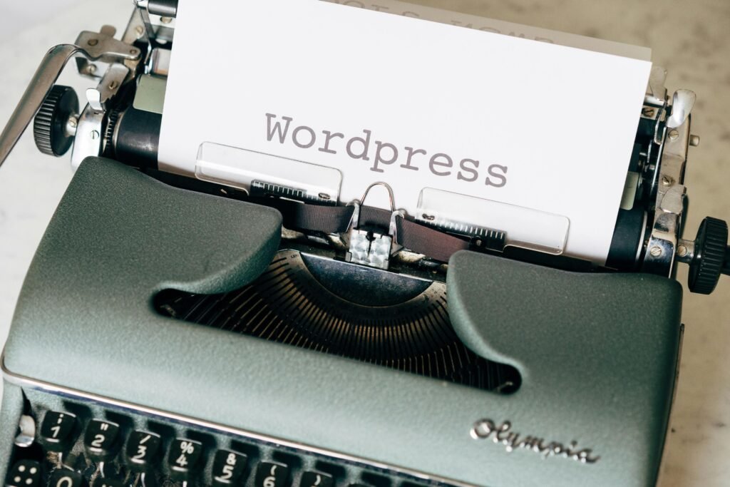 Close-up of a vintage Olympia typewriter with "Wordpress" typed on a white sheet of paper.