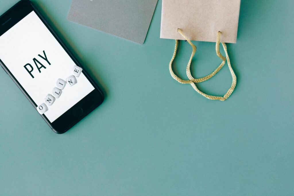 Smartphone displays "PAY ONLINE" next to a shopping bag and credit card.