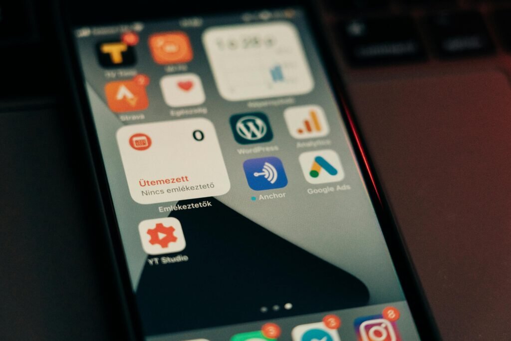 A smartphone screen displays various app icons, including WordPress, Google Ads, and YouTube Studio.