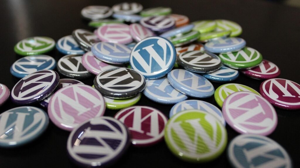 Pile of colorful WordPress logo buttons on a dark surface