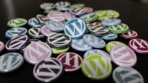 Pile of colorful WordPress logo buttons on a dark surface