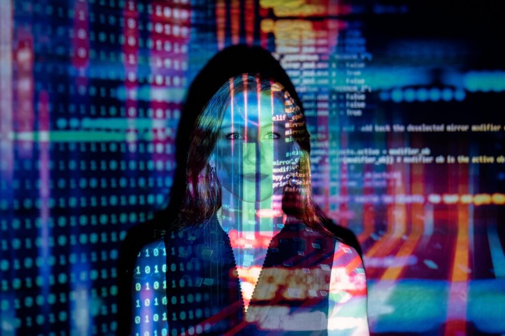 A woman's face is illuminated by projected binary code and colorful abstract patterns, suggesting the theme of ai alt text generators