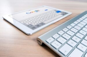 A tablet displaying the Google search page sits next to a silver keyboard, suggesting a focus on google image search rank