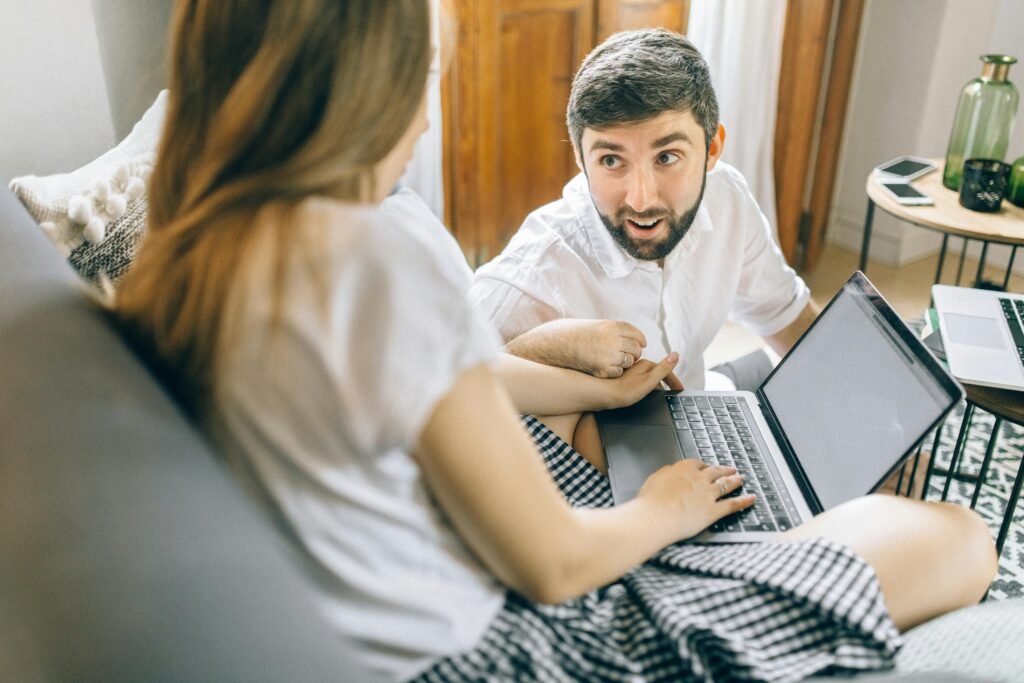 A man and woman look at a laptop, possibly using a Chrome AI alt text generator