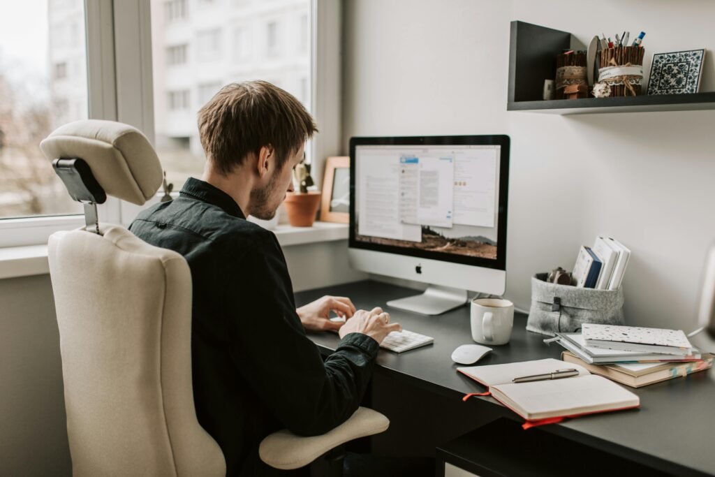 A man works on his computer, surrounded by office supplies, illustrating the importance of core web vitals images for SEO success