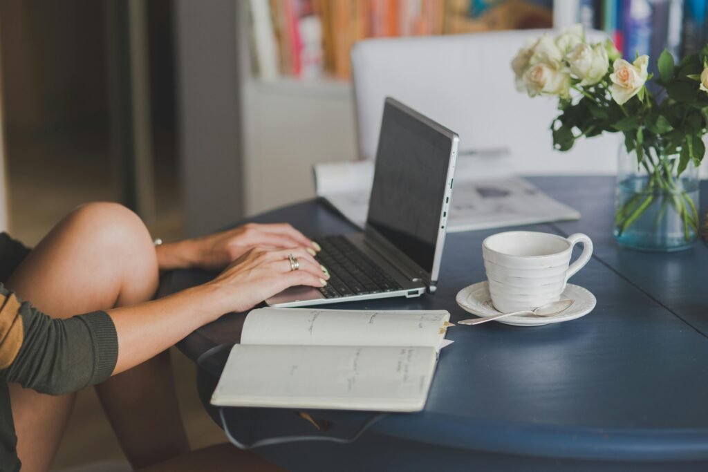 A person types on a laptop at a table with a cup of coffee and a bouquet of roses, illustrating the importance of core web vitals images for SEO success